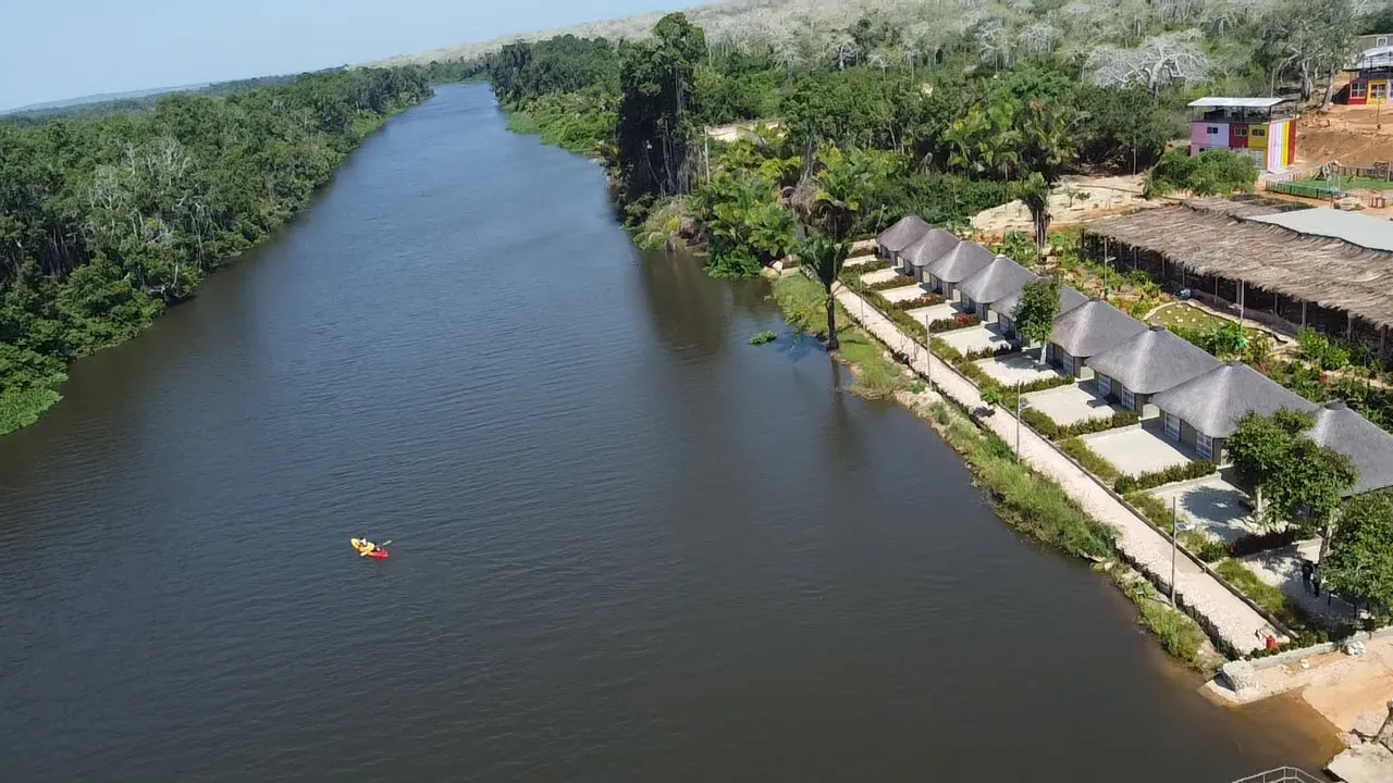 Aerial view of a kayaker paddling the Kwanza River beside the resort's chalet row