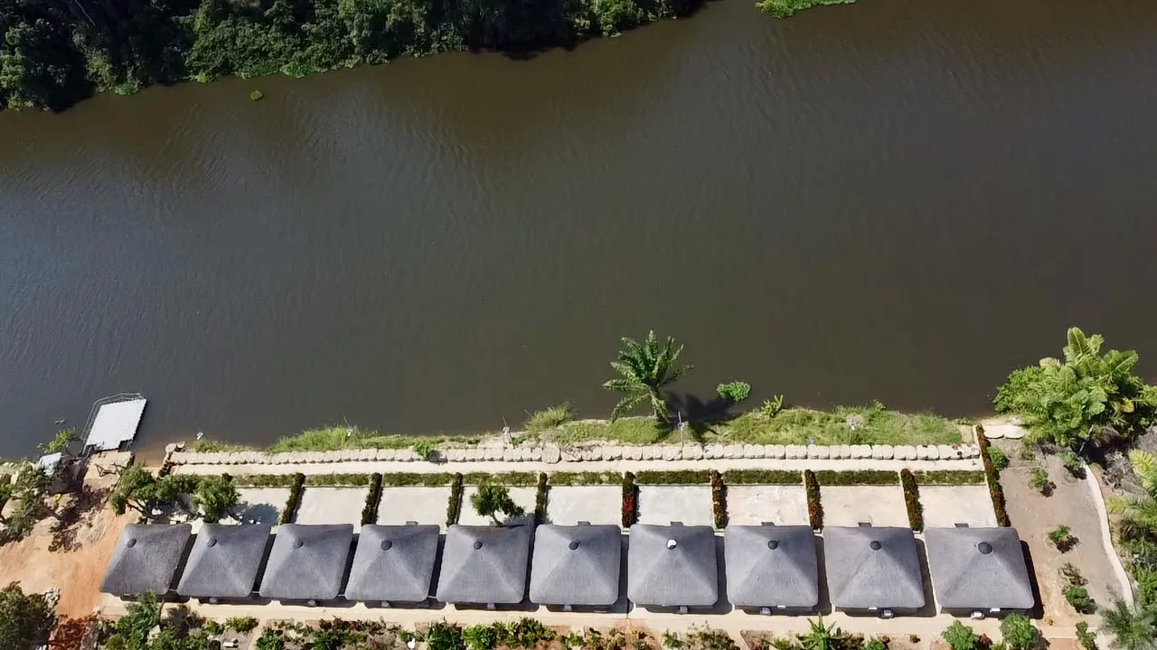 Top-down aerial view of chalet rooftops lining the Kwanza River